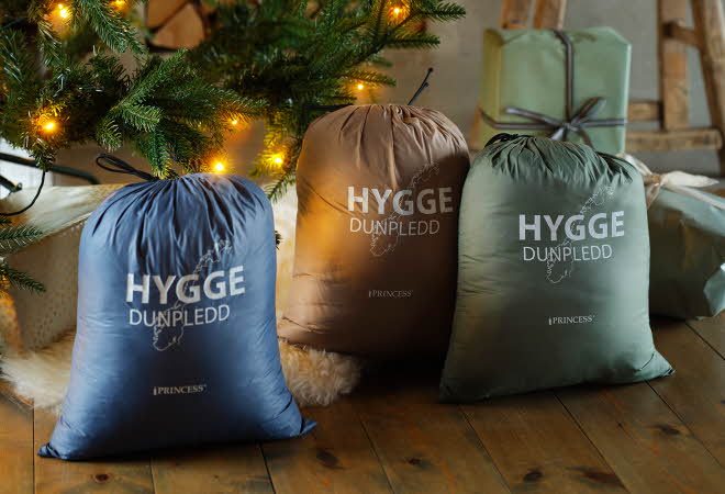 En blå, en beige og en grønn bag med Hygge dunpledd.