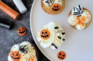 Fire muffins med krem og halloween pynt på.