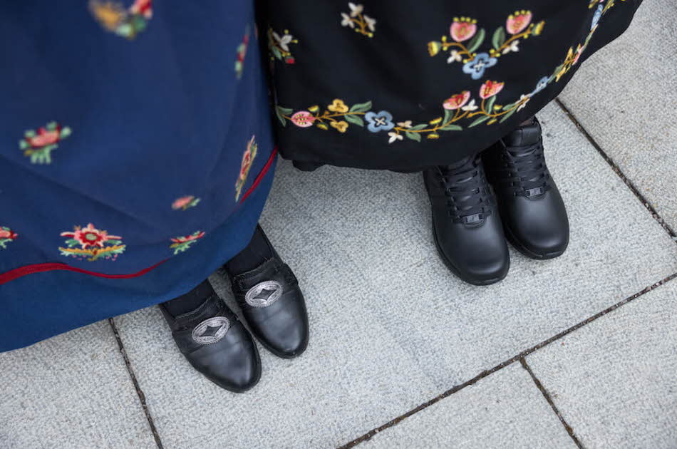 To kvinner med bunad og Gaitline-sko på, kun beina som synes
