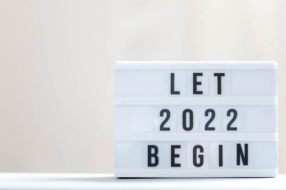 Hvit figur med sort tekst: Let 2022 begin. Hvitt underlag og lysegrå bakgrunn.