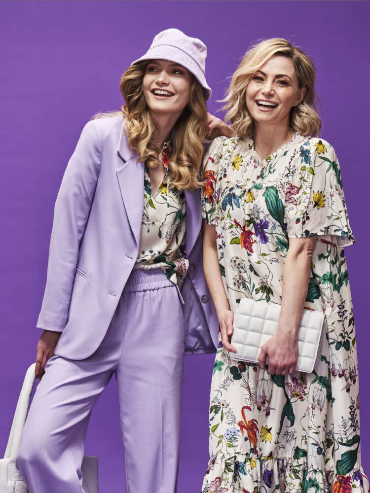 Lilla bakgrunn med to damer, en med lilla drakt og en med mønstret sommerkjole