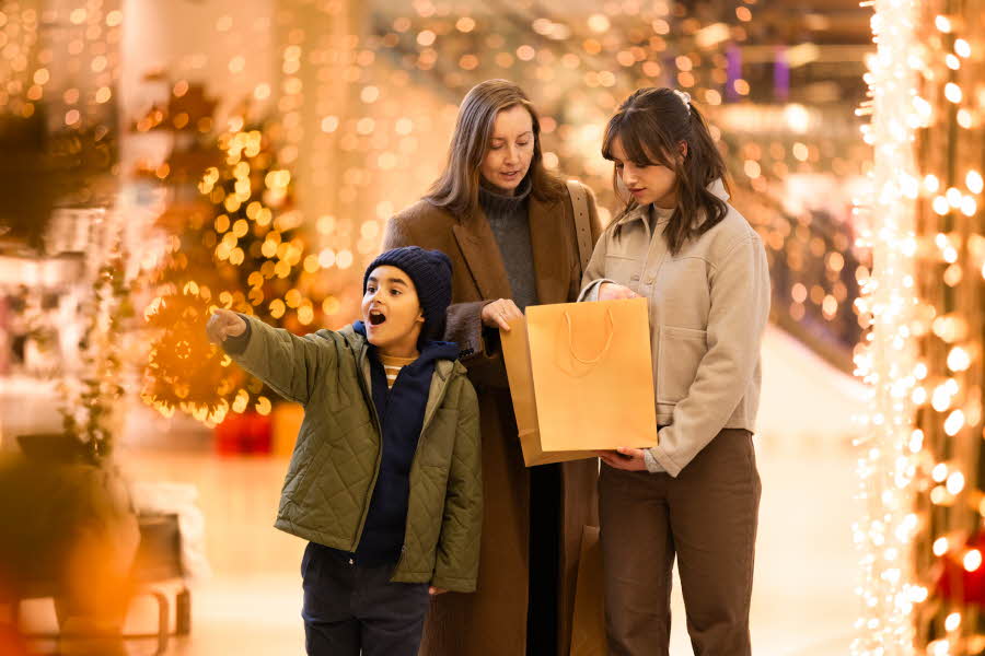 AMFI bilde av familie som handler og et glad gutt som peker mot juletre