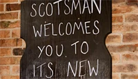 Skilt der det står "Scotsman welcomes you to its new bar"