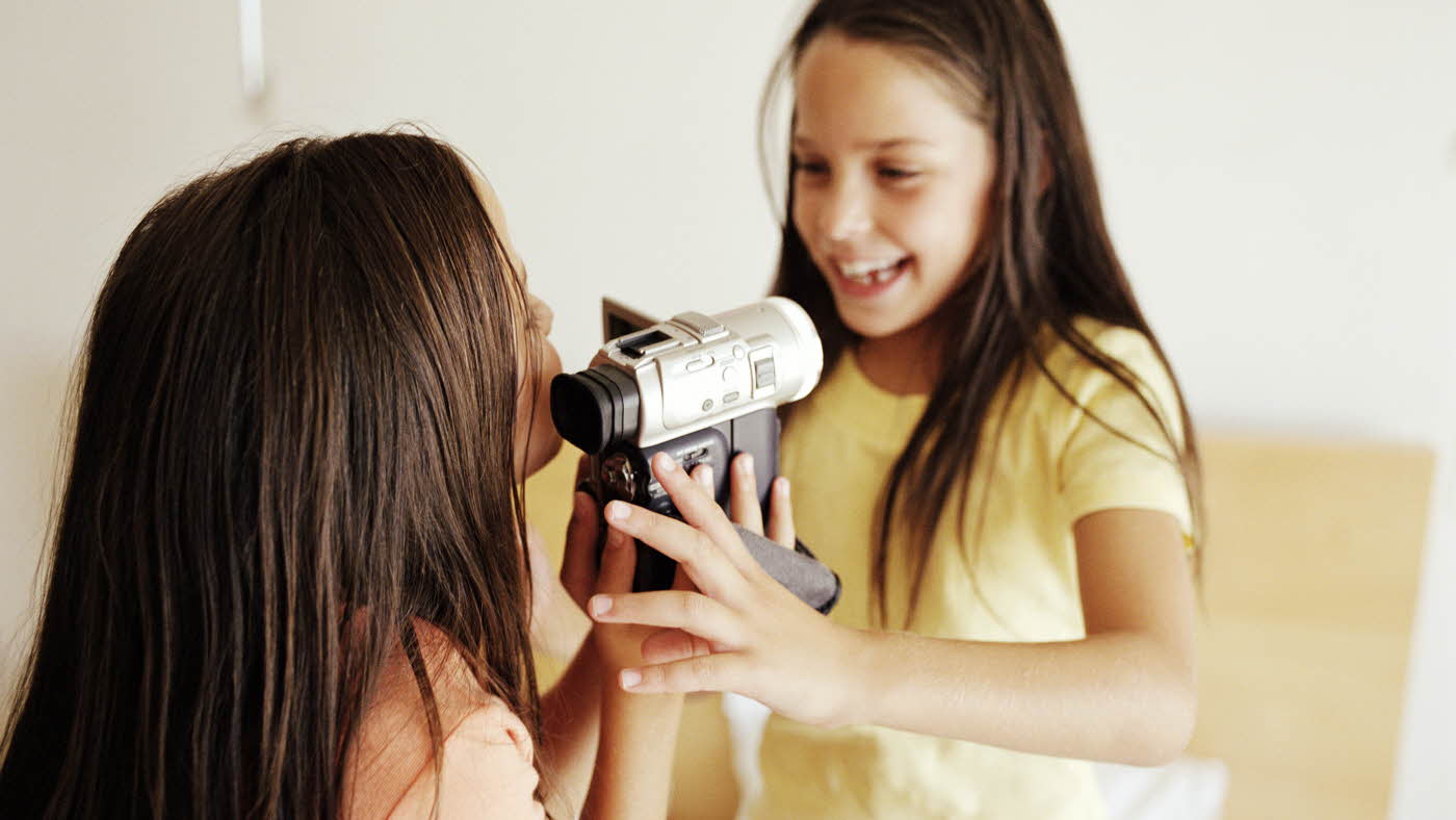 to jenter som holder et videokamera og filmer hverandre