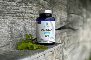 Omega 3-tilskudd på en treoverflate med grønne blader.