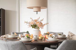 Et bord dekket til middag med en vase med blomster i midten