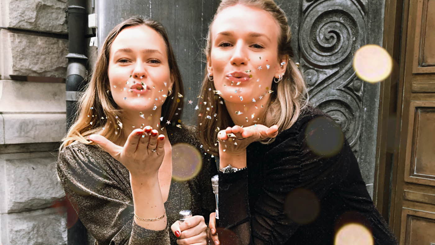 to damer som blåser confetti