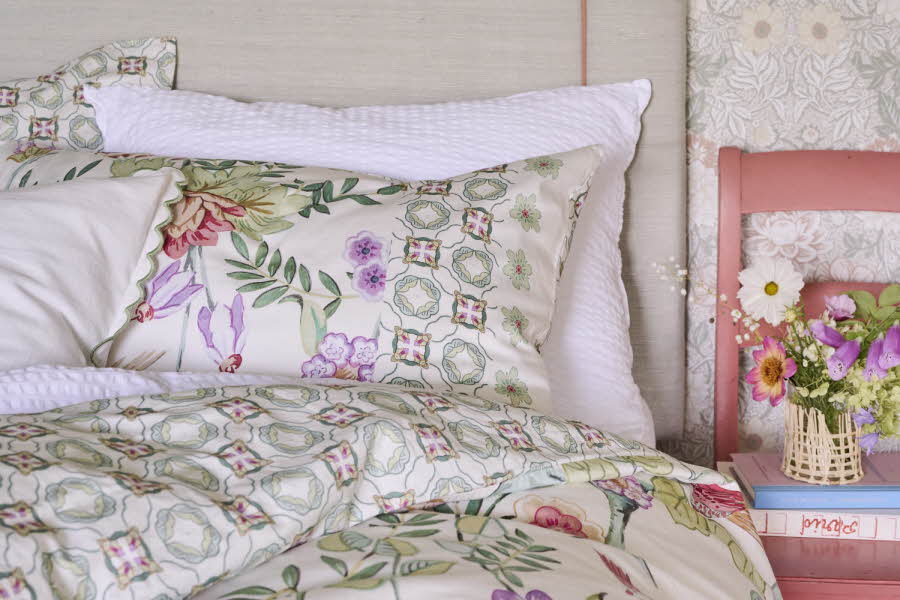 En seng trukket med et blomstrete sengesett