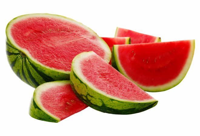 En halv vannmelon med flere oppkuttede biter med vannmelon ved siden av