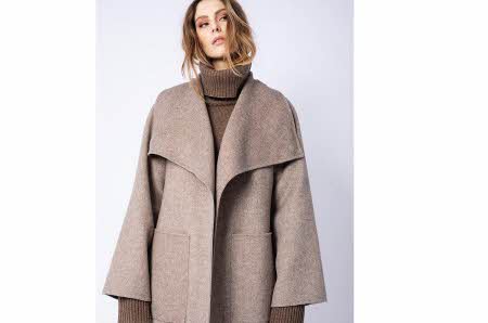 dame med brun høyhalset genser og stor, beige ulljakke