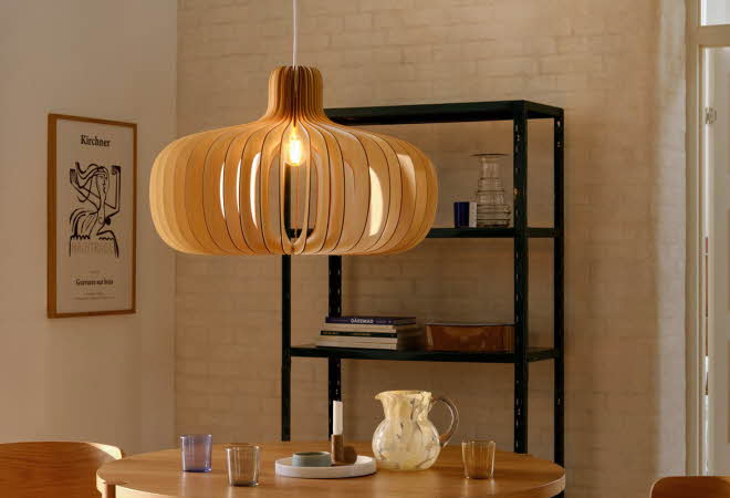 En stor, rund lampe som henger over et spisebord