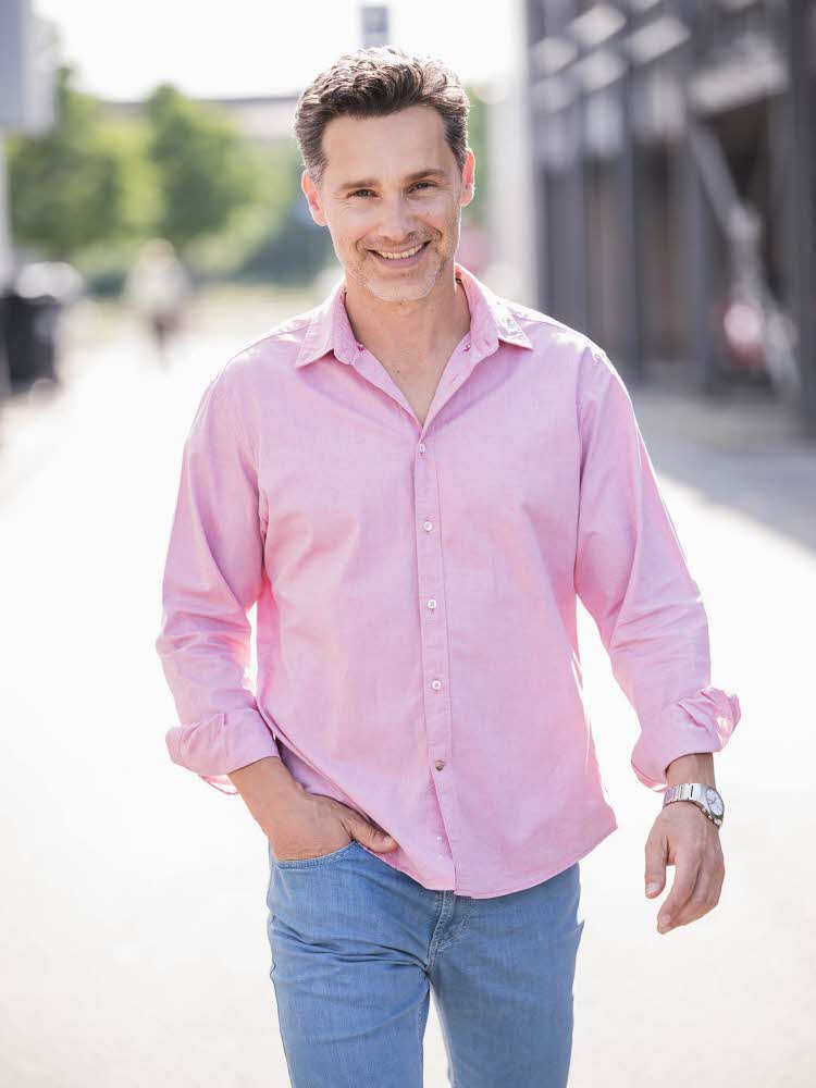 gående mann med lyserosa skjorte