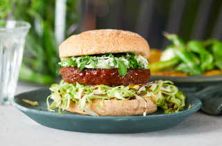 En hamburger med salat, kjøtt og brød.