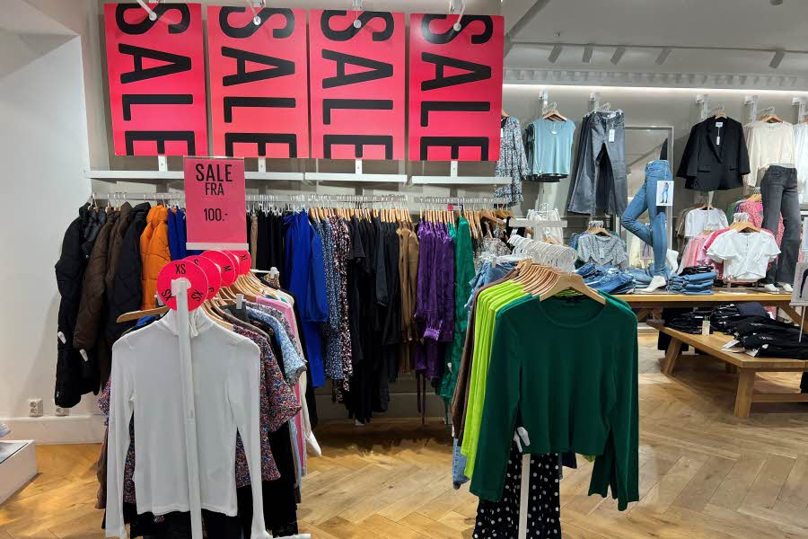 Hjørne hos ONLY som brukes som Outlet. Flere typer klær henger samlet under plakater det står "SALE" på