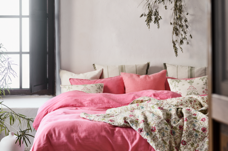 Seng med rosa sengesett og blomstersengesett