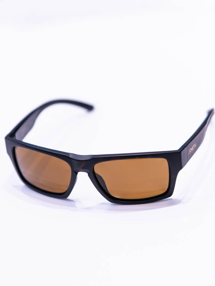 Brune solbriller som ligger på et hvitt bord med lysebrune brilleglass
