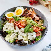 bolle med salat, egg, tomat, guacamole, fetaost og andre blad grønnsaker