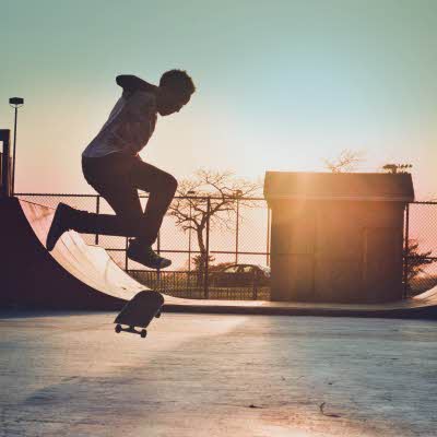 Mann skater på skateboard i skatepark