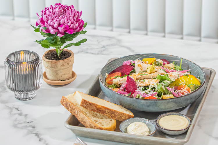 Salat, brød og dressing på et serveringsfat