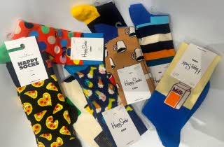 Forskjellige farvede Happysocks ligger på hvit bakgrunn