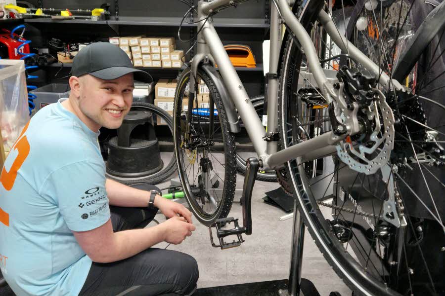 Medarbeider hos Anton Sport fikser en sykkel