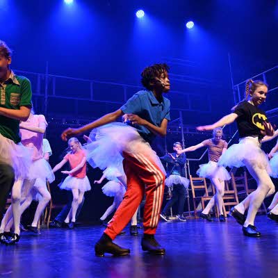 Barn og tenåringer som danser med på scene