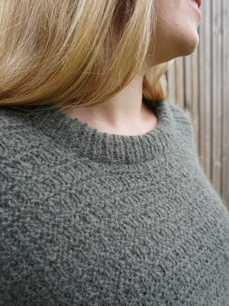 Nærbilde av grønn strikket genser