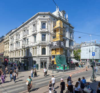 Totalbilde av Koppgården på Stortorvet 2, med yrende folkeliv på Karl Johans gate i forgrunn