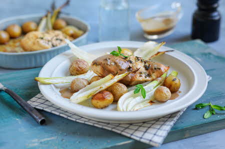 En hvit tallerken med stekt kyllingfilet, poteter og saus