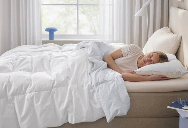bilde av en dame som sover i en seng med heatflex dyne