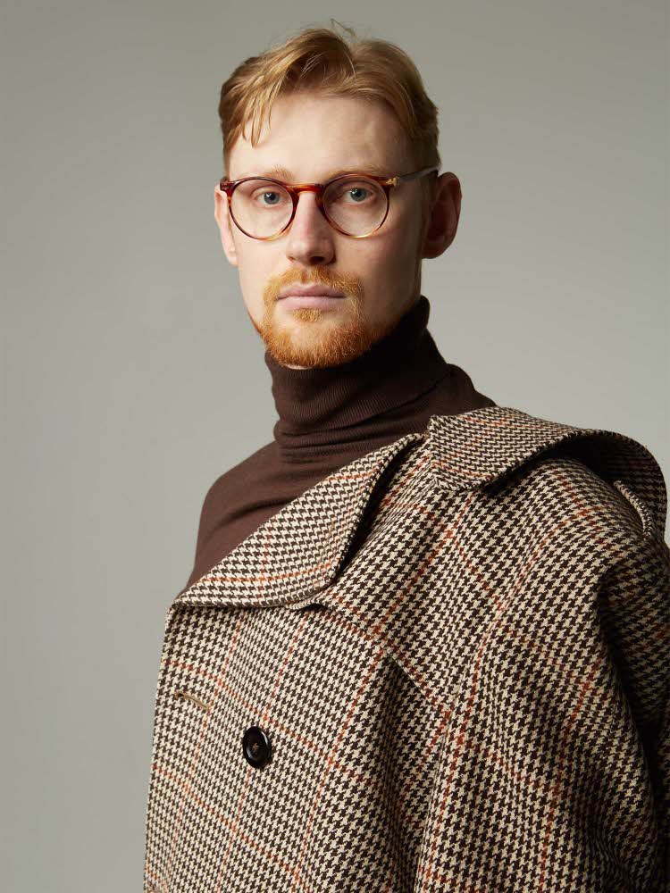 portrett av mann med briller, brun turtleneck genser og rutete høst kåpe