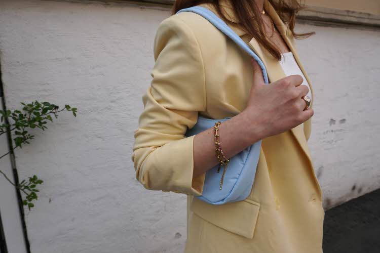 Nærbilde av en kvinne med pastellgul shorts og matchende blazer