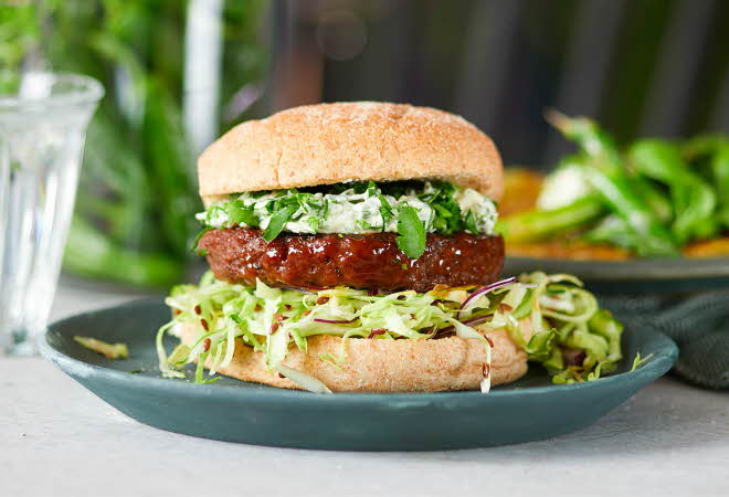En hamburger med salat, kjøtt og brød.