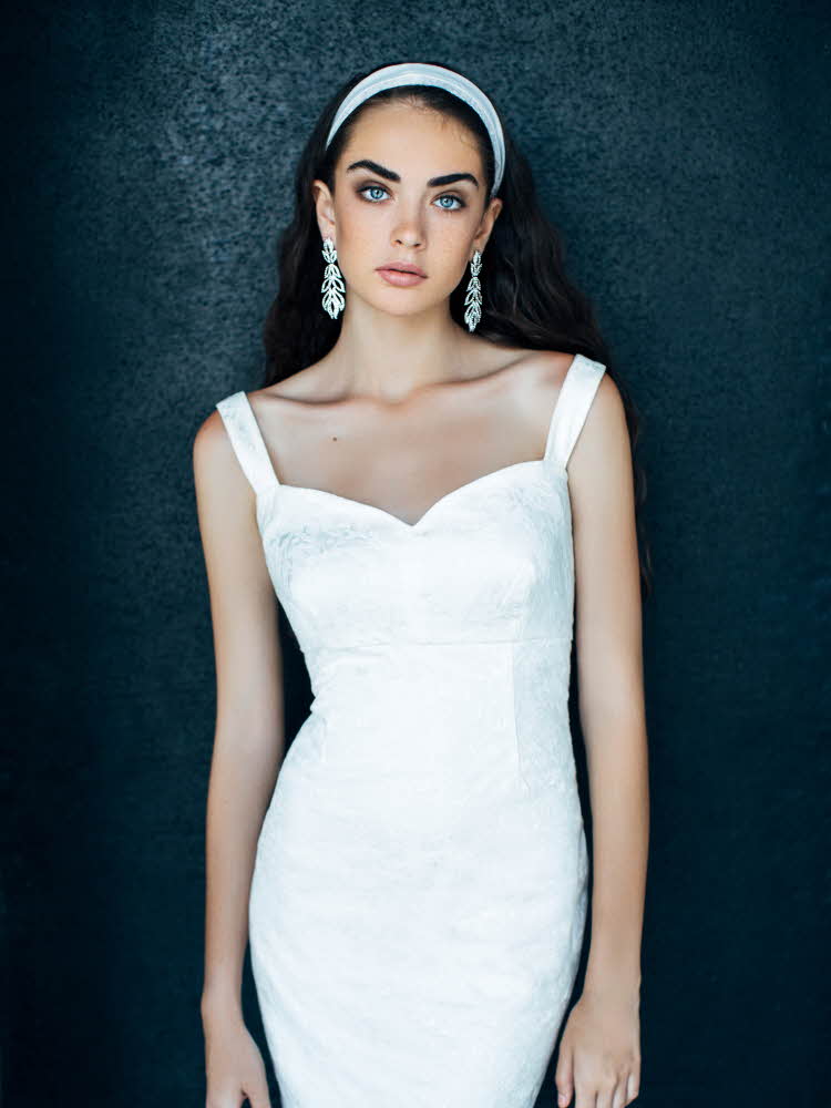 Modell poserer med hvit kjole og hårbøyle