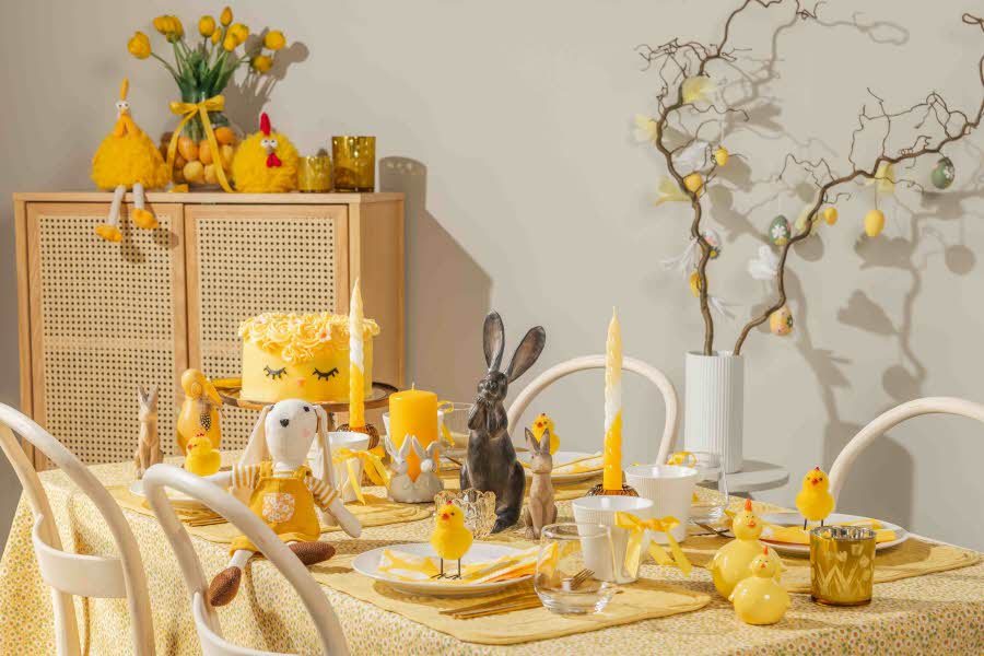 Et spisestuebord dekket på til et påskemåltid, med mye gult og påskedekorasjon
