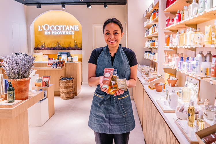 Dame som holder frem produkter på Loccitane