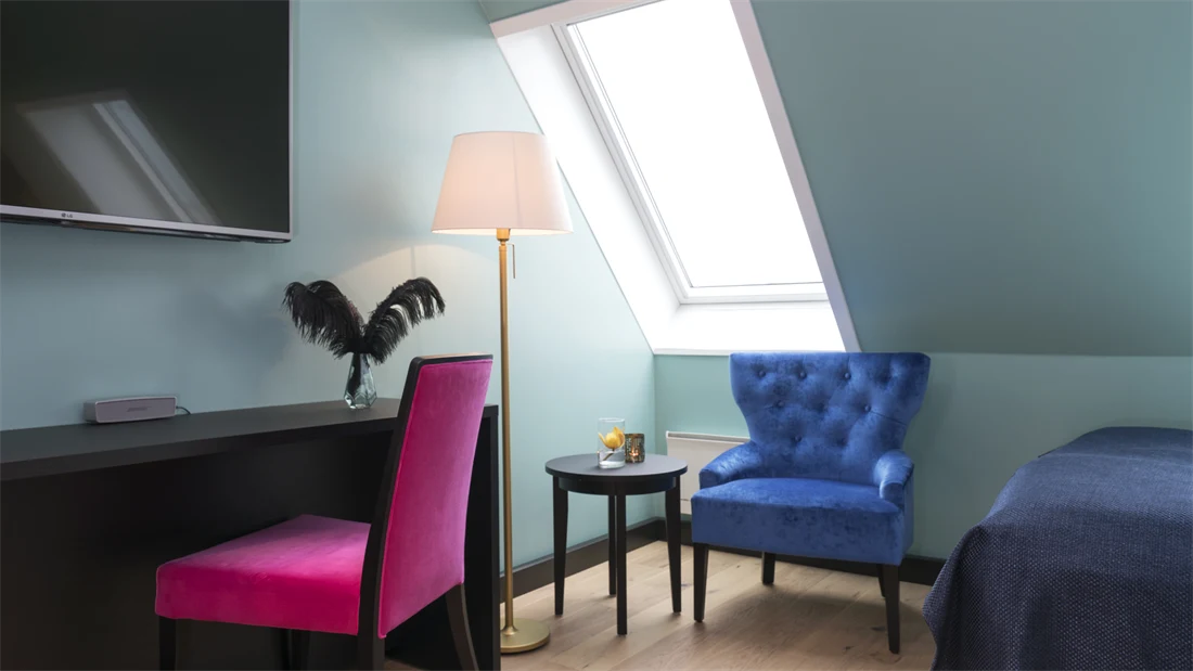 TV, skrivepult skrått tak med vindu og stol på suite på Thon hotel Terminus i Oslo sentrum nær Jernbanetorget