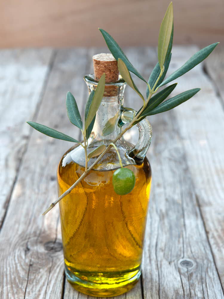Flaske med olivenolje dekorert med kvist.