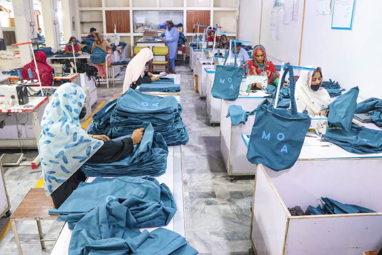 Ansatte på fabrikken syr og stryker poser