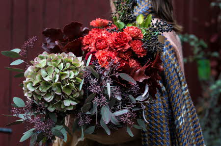 Dame som holder flere blomster buketter