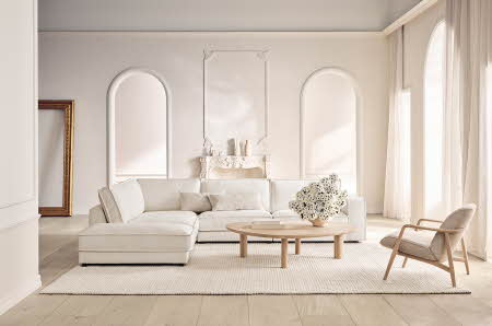 En stue med en hvit sofa en en hvit lenestol