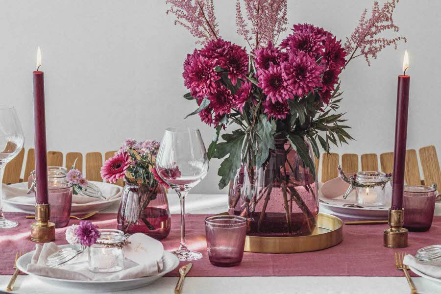 Et dekket bord med blomster, stearinslys og innredning fra Christiania Glasmagasin