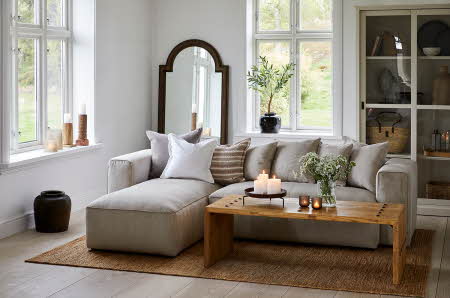 stue med sofa, stuebord, diverse duftlys og stearinlys