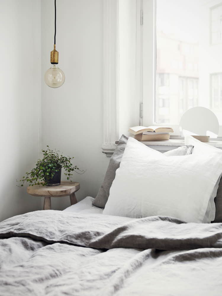 Seng med grått og hvitt sengetøy