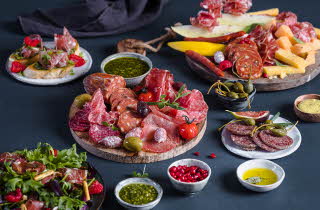 Et bord dekket med masse spekemat, ost og salat