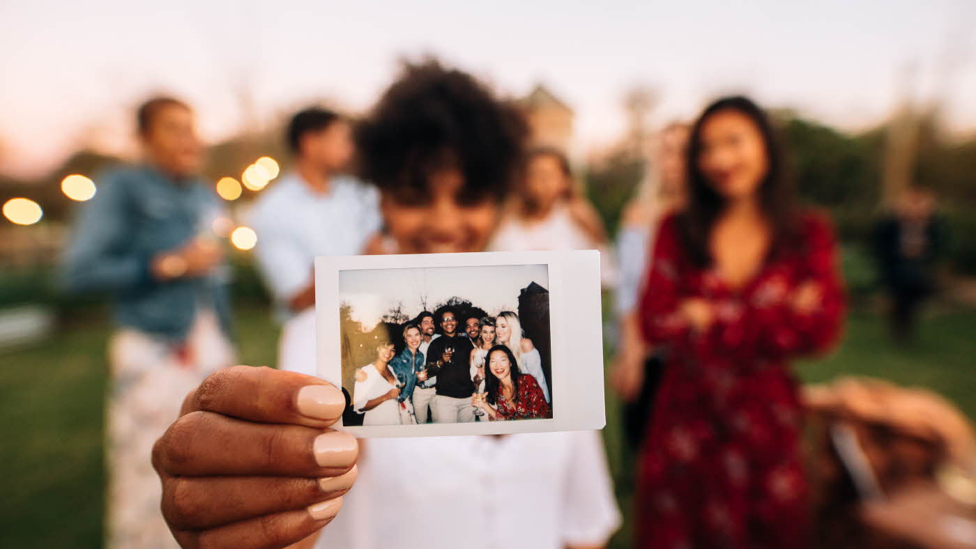 Fokus på polaroidbilde foran en vennegjeng