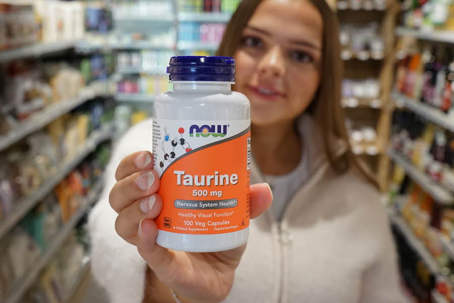 Dame holder en Now Taurine-boks