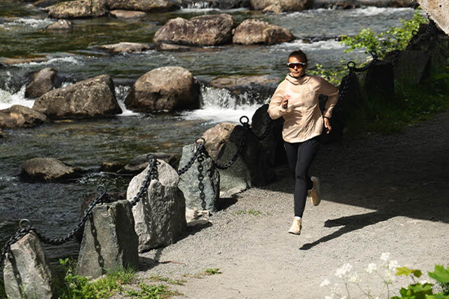 En kvinne løper i norsk natur