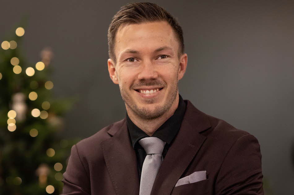 Martin Linnes står foran juletreet