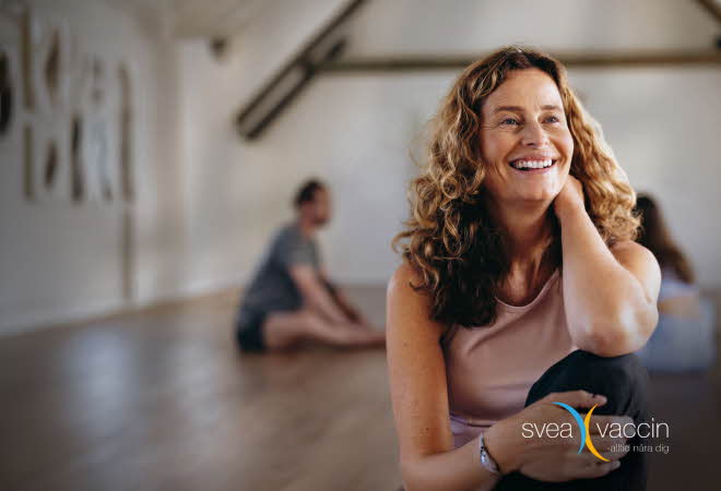 Dame som sitter innendørs med logoen Svea Vaccin.